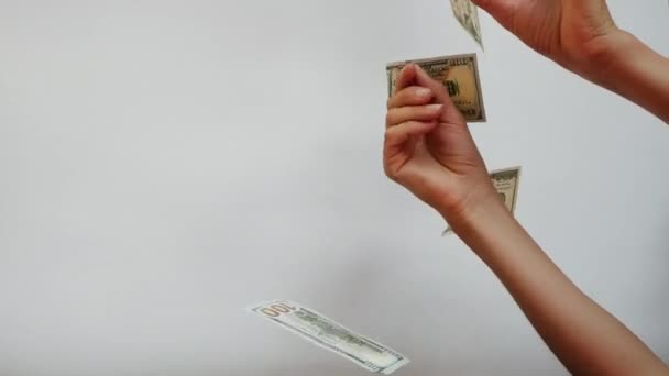 Χέρια που πιάνουν χαρτονομίσματα των 100 δολαρίων, απομονωμένα σε λευκό φόντο. Τα γυναικεία χέρια προσπαθούν να πιάσουν χαρτονόμισμα να πέφτει από ψηλά. Πλούσια ζωή με υψηλά κέρδη και οικονομικά. Τα χρήματα πετούν στο - Πλάνα, βίντεο