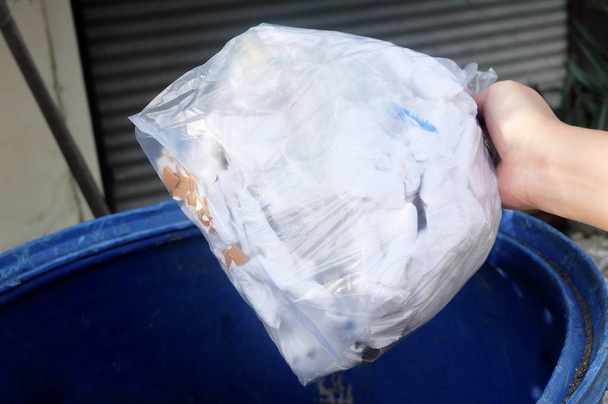 Sacar a mano la bolsa de basura en el cubo de basura o cubo de basura, papelera, papelera de reciclaje para salvar el concepto de la tierra
. - Foto, Imagen