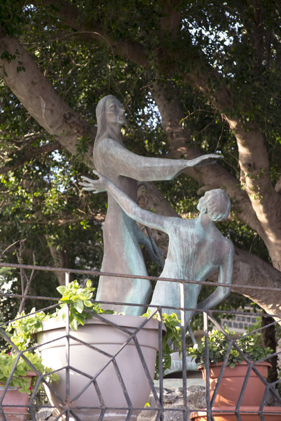 Bronz szobor áll az udvaron a templom az Elsődleges Szent Péter, található partjainál a Galileai-tenger Tabgha, Izrael. Jézus elküldi Pétert, mondván: "Etesd a juhaimat, etesd a bárányaimat" - Fotó, kép