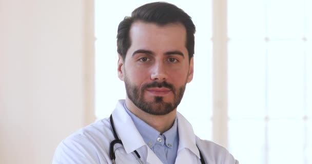 Smiling confident male doctor wear white uniform looking at camera - Metraje, vídeo