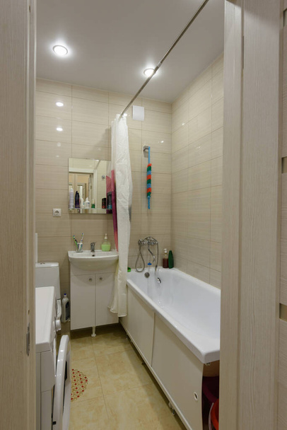 De entree naar de gemeubileerde badkamer wordt gecombineerd met het toilet - Foto, afbeelding