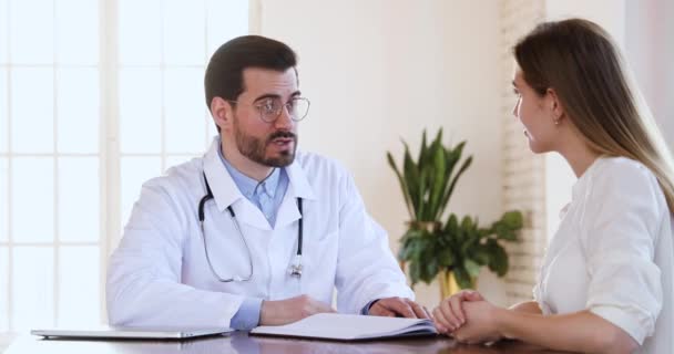 Médico sorridente e mulher paciente aperto de mão durante consulta médica
 - Filmagem, Vídeo