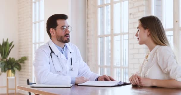 Médico calificado consulta paciente joven en visita de chequeo
 - Metraje, vídeo
