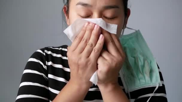 Asian young woman blowing nose in a tissue feel sick at outdoor from polluted air. Nosebleed women. Concepts of air pollution, dust allergies and health care. - Footage, Video