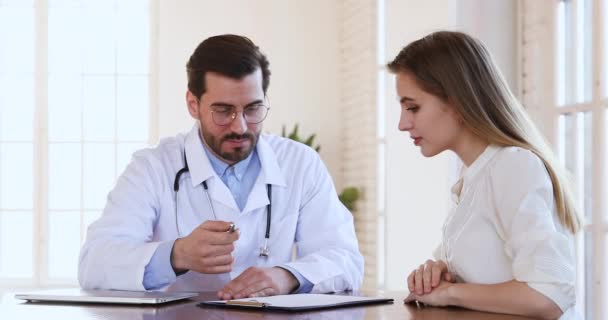 Happy young adult female patient sign medical document handshake doctor - Video, Çekim