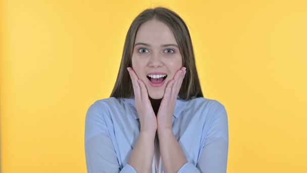 Νεαρή γυναίκα ενθουσιασμένος για έκπληξη, κίτρινο φόντο - Φωτογραφία, εικόνα