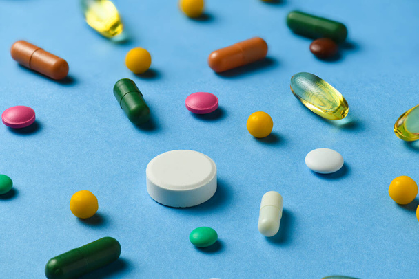 Background of pills, tablets, vitamins, drugs, omega 3 fish oil, gel capsules, medicament and food supplement for health care on blue - Foto, Bild