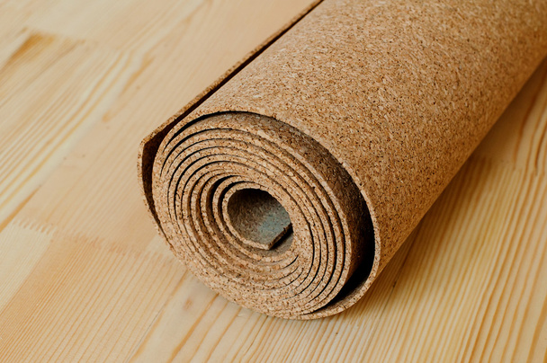 A roll of cork lies on the wooden floor - Foto, Imagen