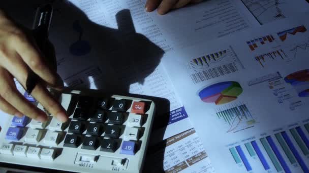 Sprawdzanie danych finansowych na wykresie firmy calculator.examining. - Materiał filmowy, wideo