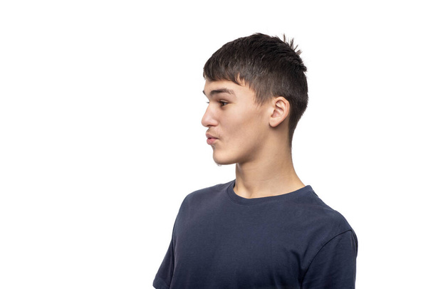 taille omhoog portret van de jonge man tiener benieuwd naar iets op een witte achtergrond in studio.  - Foto, afbeelding