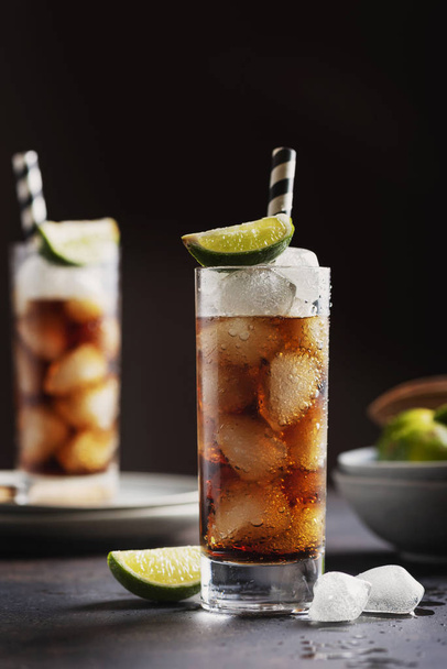 Alcoholic cocktail cuba libre with cola, rum, ice and lime, selective focus - Фото, изображение
