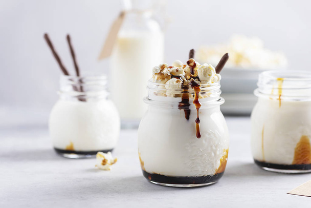Smoothie with milk, caramel and sweet popcorn, selective focus image - Фото, зображення