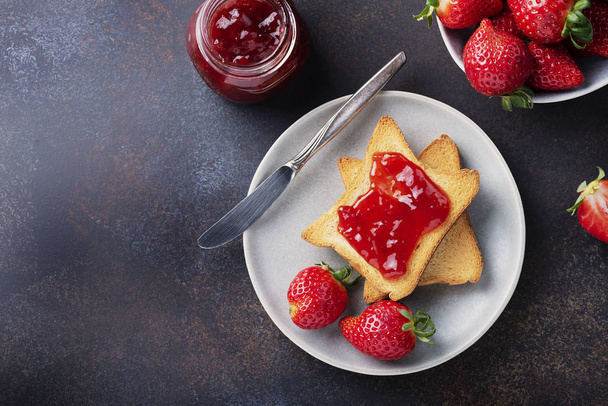 Toasts with strawberry jam for breakfast, rustic style and selective focus image - Foto, afbeelding