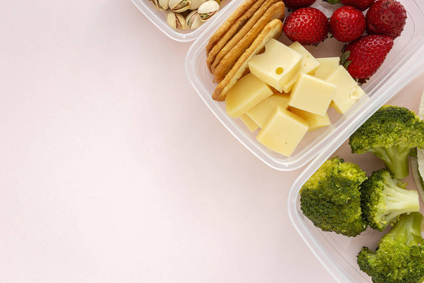 プラスチック容器の食品は、上記から食べる準備ができて奪うために。ピンクを背景に。健康食品。ビーガンフード。平敷 - 写真・画像