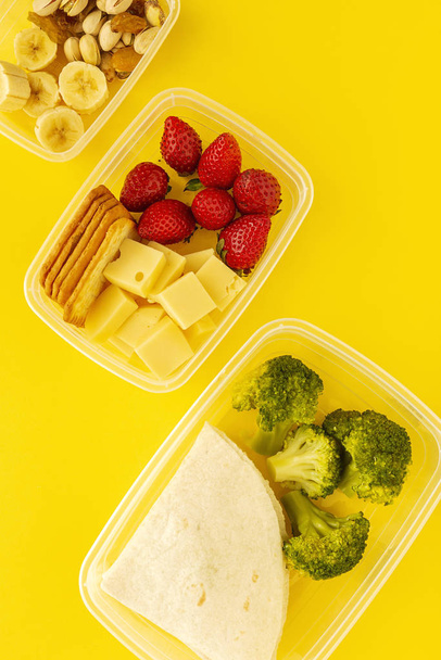 Food in Plastic containers ready to eat from above To take away. On yellow background. Healthy food. Vegan food. Flat lay - Foto, Imagem