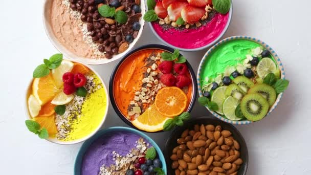 Verschiedene gesunde frische Smoothies oder Joghurts in Schalen. Mit Erdbeeren, Kiwi, Chia, Brombeeren - Filmmaterial, Video