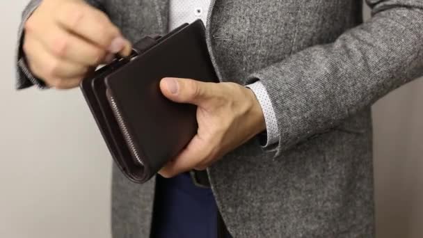 Solidní muž v šedé bundě na bílém pozadí přebírá 300 amerických dolarů z peněženky. Muž, který počítá bankovky - Záběry, video