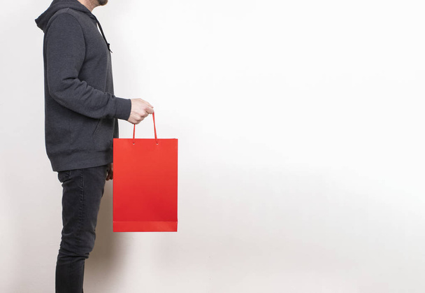 пустая бумажная сумочка для покупок макет, стоя в руке человека, модная реклама, изолированный фон - Фото, изображение
