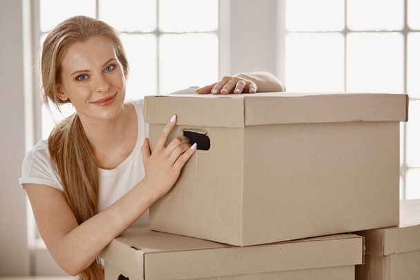 Uma bela mulher solteira desempacotar caixas e se mudar para uma nova casa - Foto, Imagem