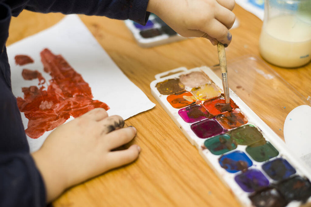 Ребенок рисует акварели на бумаге
. - Фото, изображение