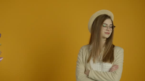 Girl in glasses refusing tulip bouquet on yellow background - Video