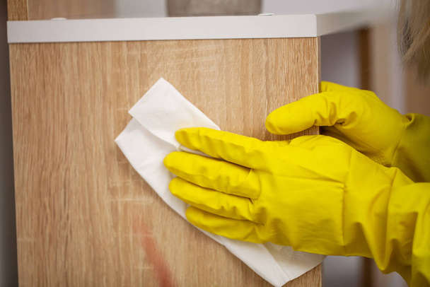 Primer plano del trabajador limpiando a mano el polvo en la oficina
 - Foto, Imagen