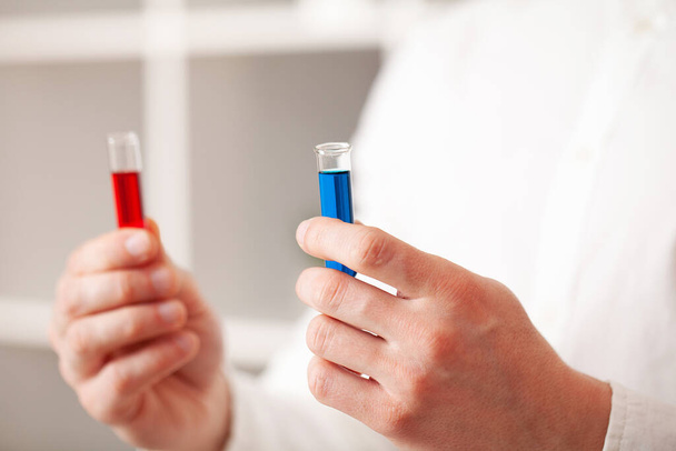 Koronavirüslü test tüpleri tutan doktorlara yakın çekim - Fotoğraf, Görsel