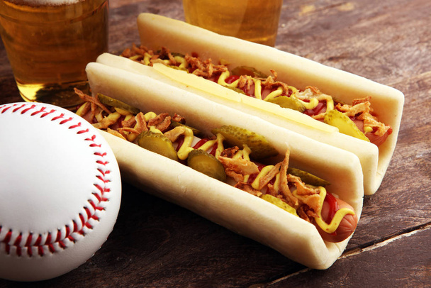 Grillowane hot dogi z musztardą i ketchupem na stole z poborowym piwem. Baseball party żywności  - Zdjęcie, obraz
