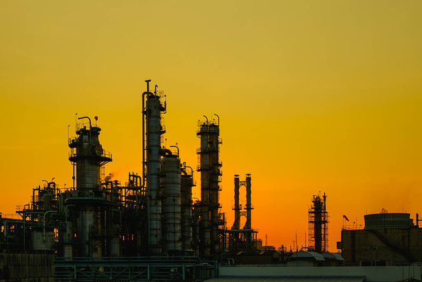 Rafineria ropy naftowej i gazu na tle pomarańczowego nieba, petrochemiczny zakład przemysłowy - Zdjęcie, obraz