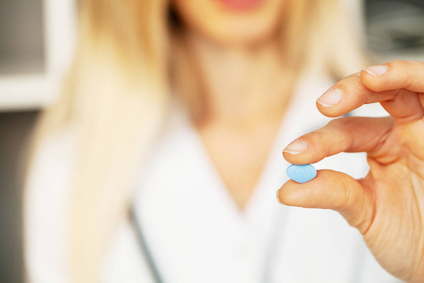 Close up of female doctor holding pill for men health - Foto, imagen