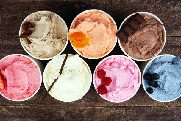 Vários de sabor de sorvete com mirtilo fresco, morango, framboesa, chocolate, configuração de baunilha em fundo rústico. Gelado de verão e doce
 - Foto, Imagem