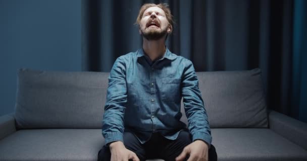 Crying Depressed Man Sitting on Sofa - Materiał filmowy, wideo