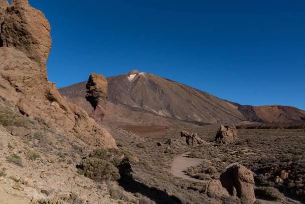 Näkymä Roques de Garcia ainutlaatuinen kallio muodostumista kuuluisa Pico del Teide vuori tulivuori huippukokouksessa taustalla auringonnousun, Teide National Park, Tenerife, Kanariansaaret, Espanja
 - Valokuva, kuva
