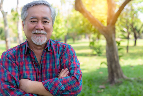 Handsome Senior asian man. Attractive handsome elderly man cross arms. Old man has good health, strong. Senior guy is retirement age. His terminal is stable of life. Grandfather get happy, enjoy life. - 写真・画像