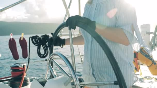 Eine Frau sitzt am Steuer einer Jacht. Frau auf einem Segelboot, Jacht während Sommerreise. - Filmmaterial, Video