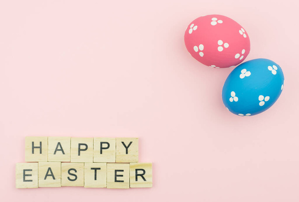 Text wooden blocks spelling the word happy easter on pink background - Photo, Image