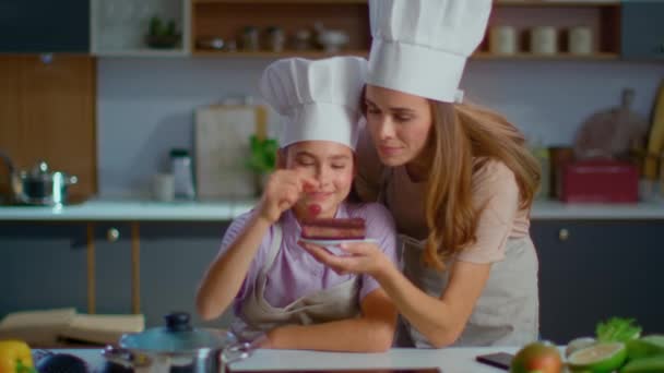 Кондитер и мама кладут вишню на торт на кухне в замедленной съемке
 - Кадры, видео