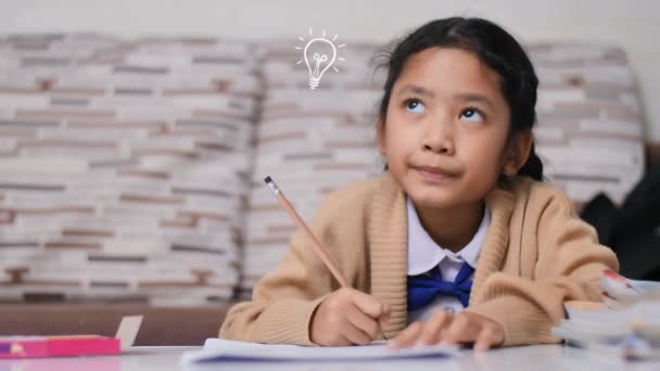 Little Asian girl doing homework with spark idea bulb animation, and chemical formula solution, Thai girl in student kindergarten uniform, learning and education at home - Felvétel, videó