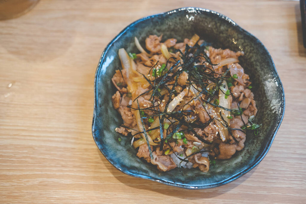 Жареная свинина на рисовой чаше в японском стиле бутадон. Японская кухня
 - Фото, изображение