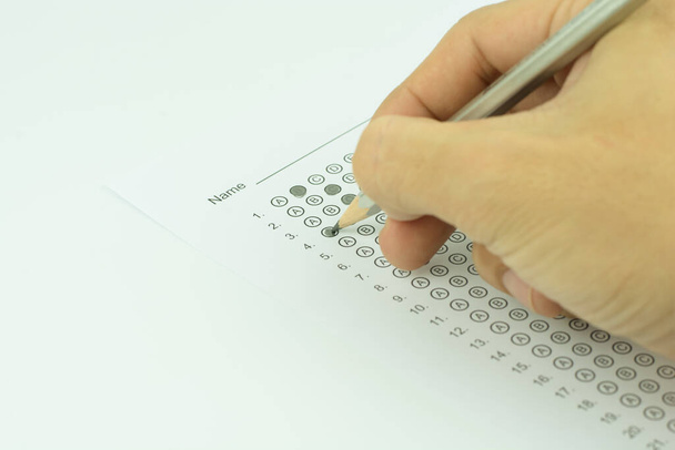 Männerhände füllen standardisiertes Testformular aus - Foto, Bild