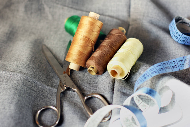 Sewing. Spools of thread on the fabric. Threads. Meter and scissors - 写真・画像