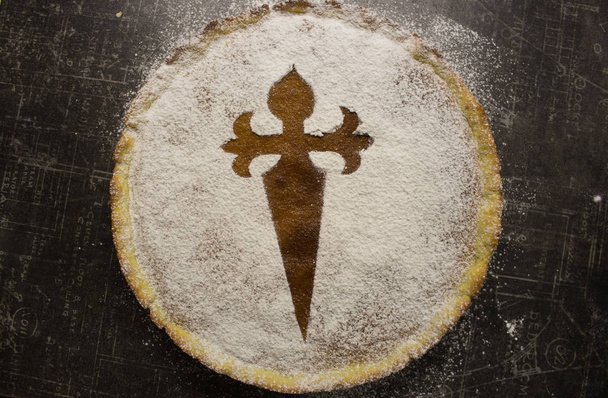 Sweet pie Santiago de Compostela. Santiago tart with sugar powder and cross. Symbol of Camino de Santiago. Homemade almond dessert. Spanish cuisine. Delicious cake. - Photo, Image