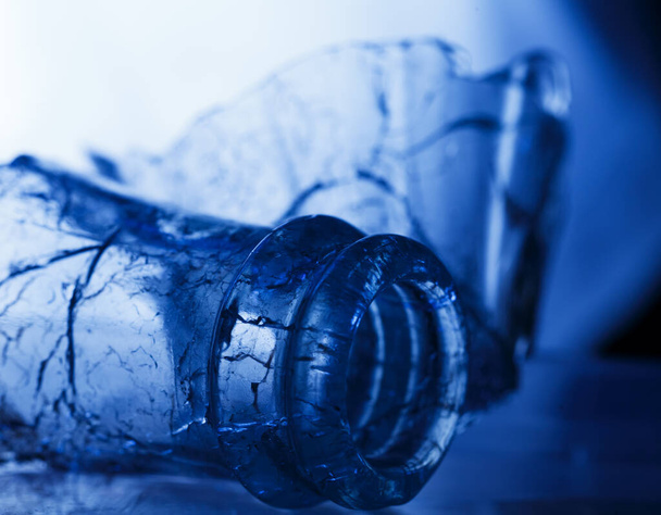 gebroken glazen fles in blauw licht - Foto, afbeelding