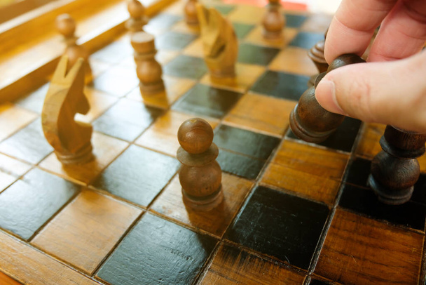 男性手を取り、相手と競争するためにボード上のチェスの馬を移動。戦略計画ボードゲームは、ビジネス、企業活動に関連しています。成功、経営、意思決定のコンセプト. - 写真・画像