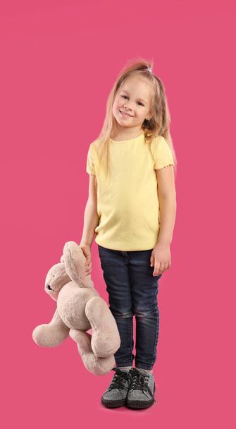 Little girl with teddy bear on pink background - Valokuva, kuva