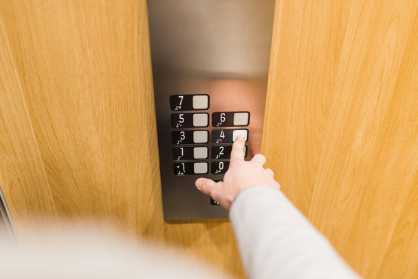 Forefinger pressing fourth floor button in the elevator. Space for copy. - Fotografie, Obrázek