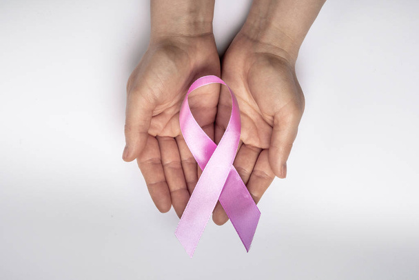 Octobre est le Mois de la sensibilisation au cancer du sein. Mains tenant un ruban rose pour soutenir les personnes vivant et malades. Santé, Journée internationale de la femme et concept de Journée mondiale du cancer
. - Photo, image