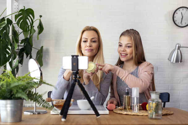 Mum and her daughter recording video blog at home with makeup theme - Foto, Imagem