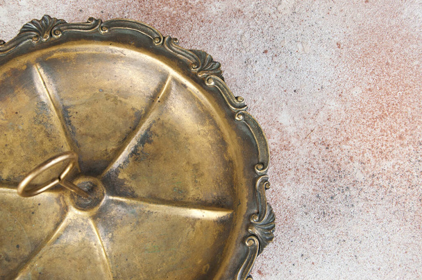 Antique brass serving dish with ring handle for desserts or appetizers with tea time on concrete background. Food photography props and copy space for text - Fotoğraf, Görsel