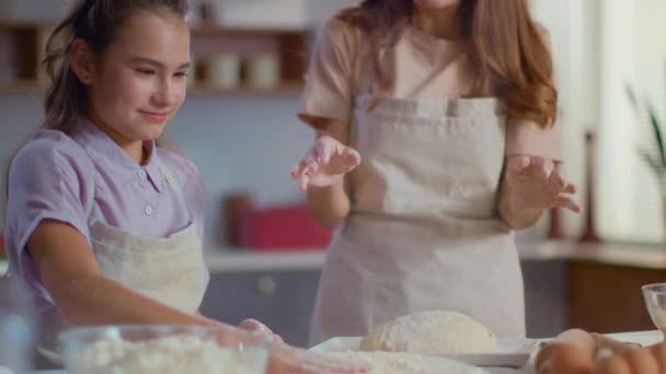 Woman and girl clapping hand on flour at modern kitchen in slow motion - Záběry, video